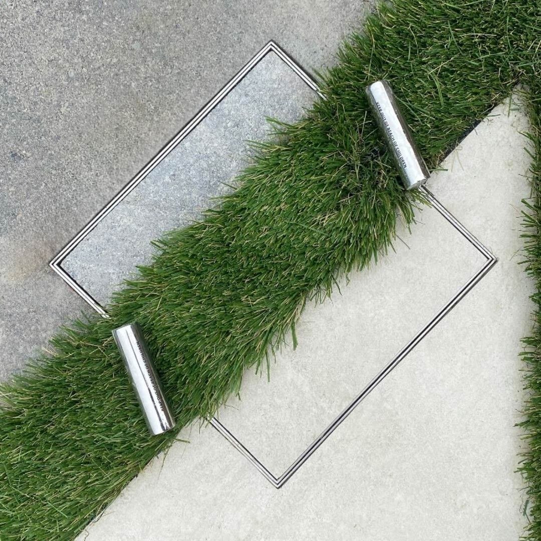 HIDE Skimmer Lid with artificial turf and concrete paving inlay installed flush with surrounding landscape.