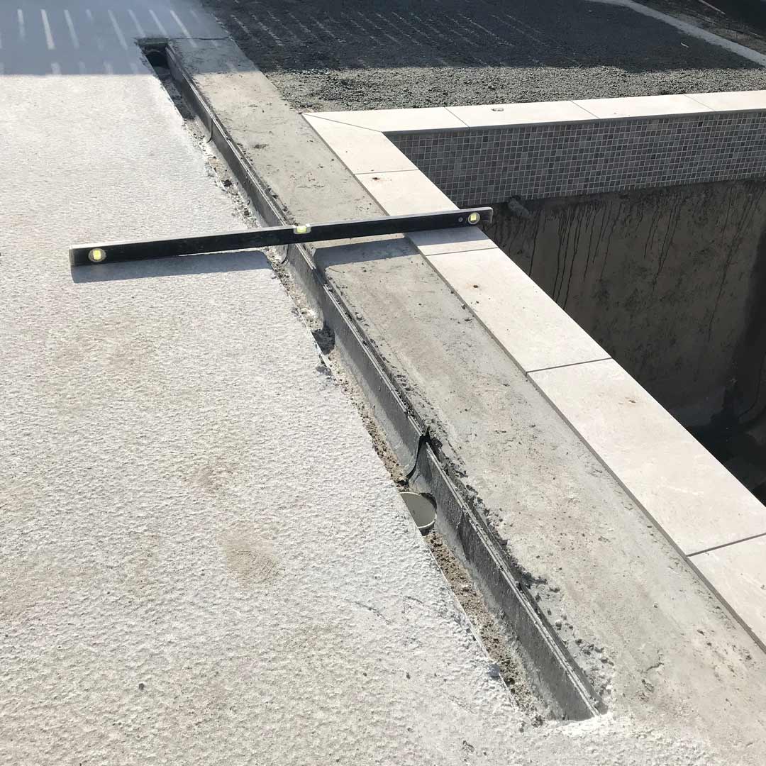 Poured concrete slab ready and flush to install HIDE Tile Linear Strip Drain Cover.