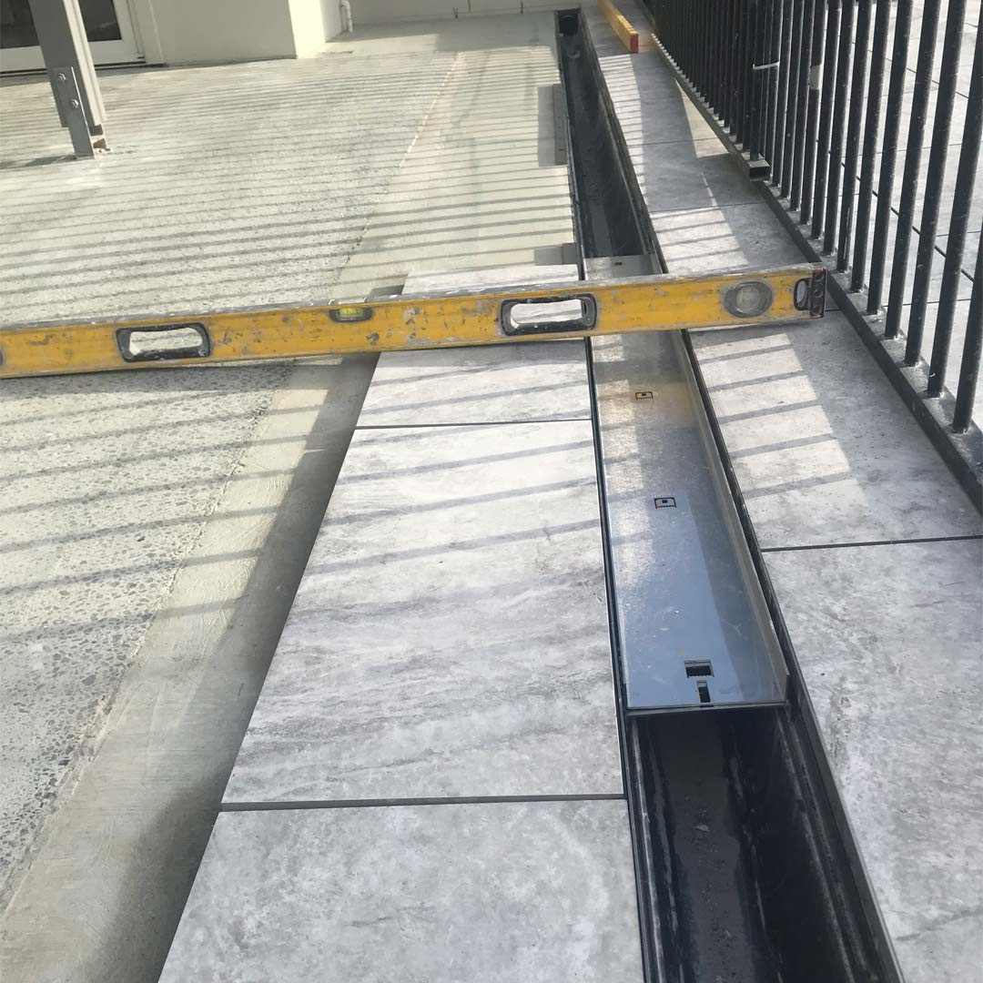 HIDE Linear Strip Drain Cover installed flush with tile surrounds.